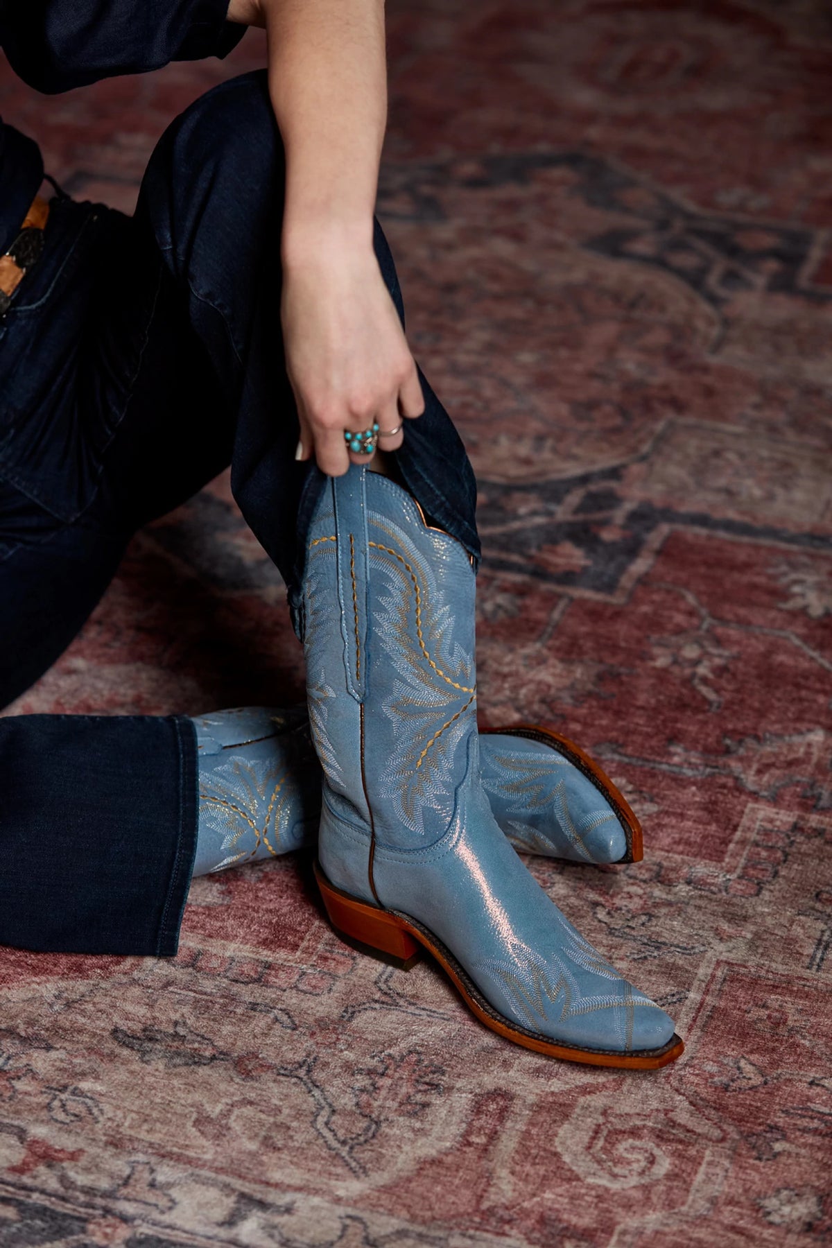 Tilly Indigo Blue Shimmer — close-up, model's hand on boot shaft 3
